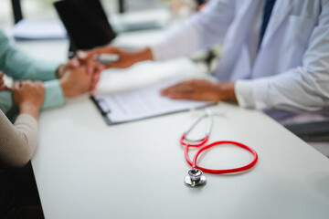 Doctor explaining diagnosis to worried patients in hospital room