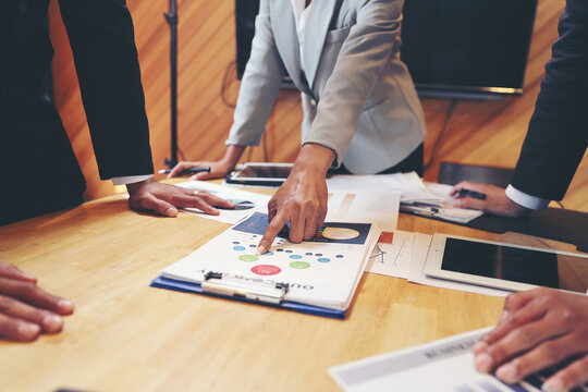 A group of business people are meeting to analyze data for marketing plan