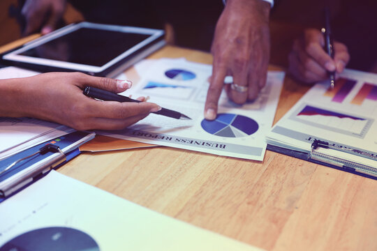 A group of business people are meeting to analyze data for marketing plan