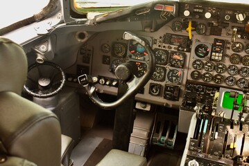 Modern airplane cockpit interior with active flight instruments and illuminated control panels during flight.