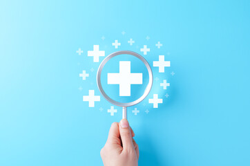 Plus Sign Symbol. Magnifying glass focusing on white plus sign with small plus symbols, symbolizing benefits, positivity, added value, wellness services, prevention, insurance, medical, and health.