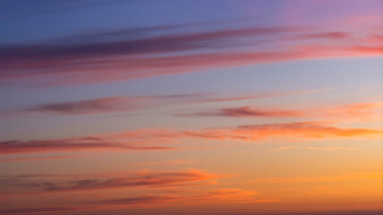 Obraz premium Vibrant sunset sky with wispy clouds painting the horizon in warm hues