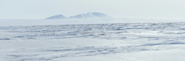 Arctic landscape. View of the snow-covered tundra and snow-capped mountains. Cold weather. The harsh climate of the polar region. Nature of the Arctic. Wide panorama. Great for background. © Andrei Stepanov