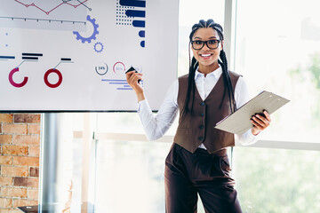 Confident businesswoman presenting analysis with charts in a professional office setting showcasing strategy and analytics