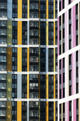Low-angle vertical close-up of vibrant apartment tower in Saint Petersburg with yellow, pink, and...