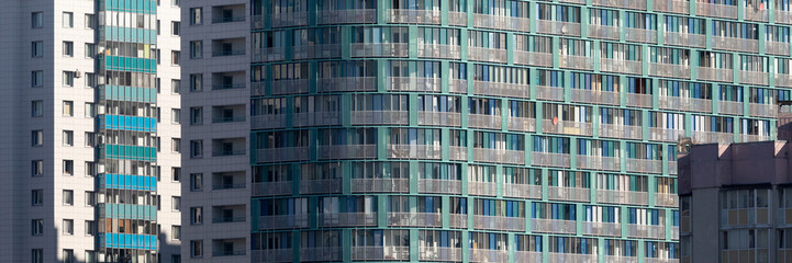 Obraz premium Close-up view of a modern residential apartment building with glass balconies, reflecting urban architecture and contemporary city housing design.