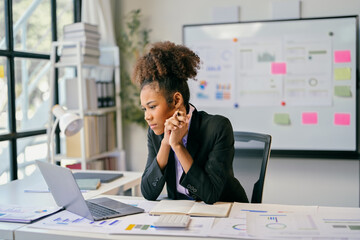 Focused african american businesswoman working with laptop in modern office