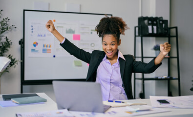 Excited african american businesswoman celebrating success in modern office