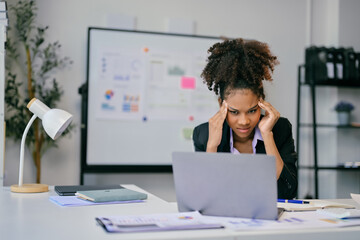 Stressed african american businesswoman having headache at office desk