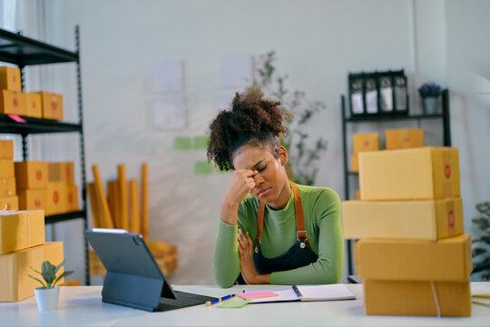 Stressed african american woman suffering from headache while working at her storehouse