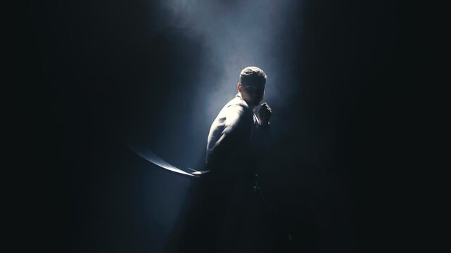 Dramatic silhouette of a performer in spotlight, showcasing dynamic movement and emotional expression, captured in a sequence of three frames highlighting the intensity of the scene