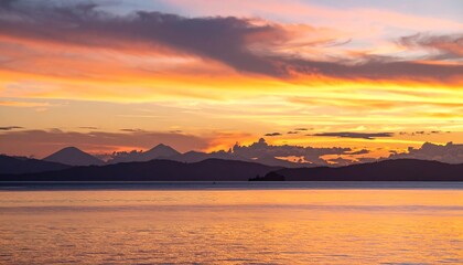 Fototapeta premium Golden Hour over tranquil waters with mountainous silhouette backdrop scene