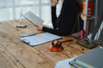 Judge reading legal documents with gavel and scales on desk