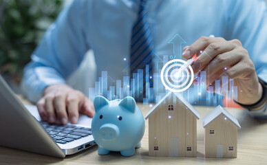 Businessman analyzing real estate investment on laptop with house, reviewing mortgage loans,...