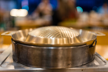 Empty metallic brass BBQ pan set on charcoal stove for grilled pork and meats