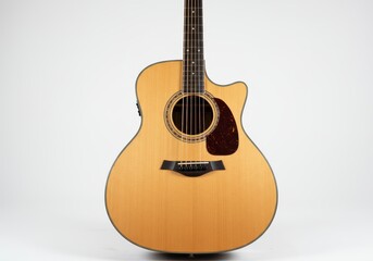 Obraz premium A well-lit, shot of a light-colored acoustic guitar against a plain white backdrop.