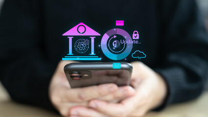A man using a smartphone with a digital hologram showing banking system update, cybersecurity,...