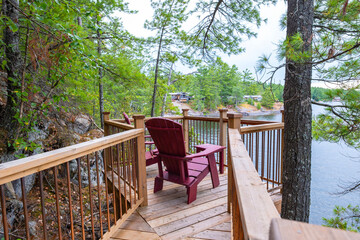 Two Red Adirondack Chairs on a Deck Overlooking French River in Ontario Cottage Country
