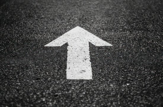 White arrow on dark asphalt