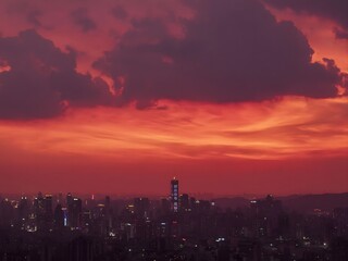 Fototapeta premium Urban Skyline with Dramatic Orange Sunset Sky and Storm Clouds Over City at Dusk