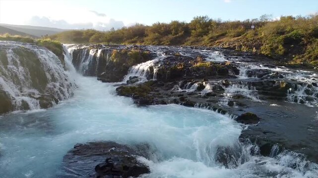 Low Angle Drone Over Br&uacute;arfoss Waterfall Sun Flare Pan