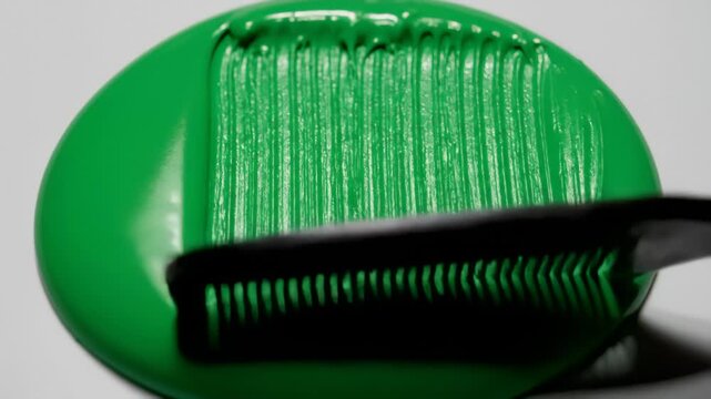 Top-down macro video of thick acrylic paint combed into parallel grooves