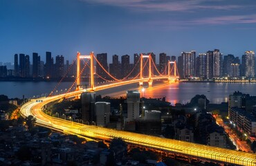 Fototapeta premium Wuhan Yangtze River Bridge at Twilight with Golden Illumination and Modern City Skyline