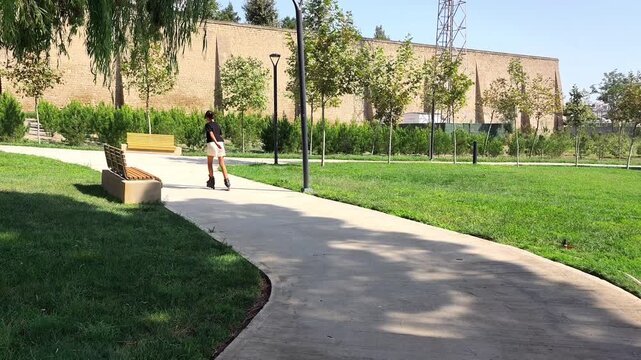 Teenage girl riding skaters roller in the park