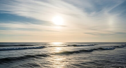 Obraz premium Scenic view of the ocean at sunset, with golden light reflecting on the water and creating a serene and peaceful atmosphere