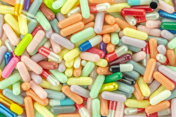 Pharmaceutical medicine background of many colorful pills and capsules for the healthcare and science industry. Drug and vitamin texture.