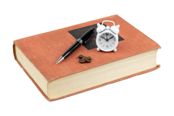 Study break time. Alarm clock and coffee beans on an old book for energy and focus. isolated on white background with clipping path.
