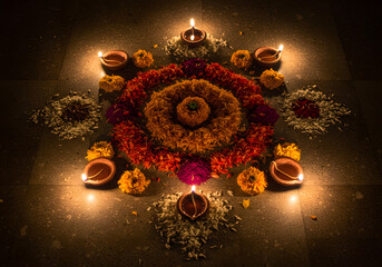 Beautiful diwali rangoli decoration with flowers and candles for celebration