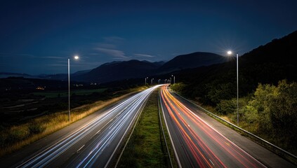 Obraz premium Night highway lights streak through dark landscape