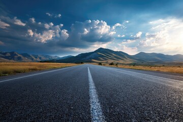 Asphalt road winding through mountains at sunset