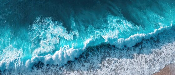 Ocean waves crashing on a shore.  Aerial view of turquoise water