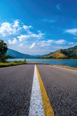 Asphalt road leading to a serene lake