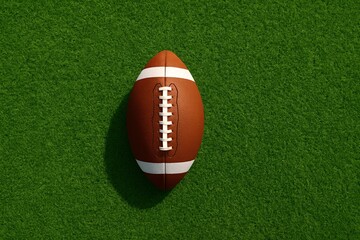 Obraz premium Vibrant American football on green grass celebrating the excitement of the Super Bowl event
