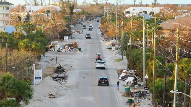 Piles of garbage from damaged homes after hurricane Milton storm surge in Florida. Debris on street side on Manasota Key in Englewood. Hurricane aftermath cleanup.