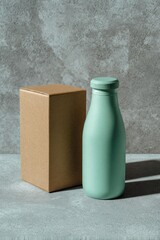 Light mint-green bottle beside a cardboard box on a textured surface
