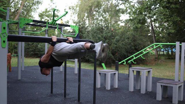 Young athlete holds strong planche on parallel bars in outdoor gym surrounded by trees demonstrating advanced street workout skills power balance and dedication to training