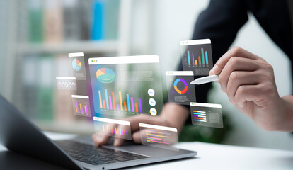 Businessman using digital dashboard with holographic graphs and charts on laptop and stylus representing data analysis financial report business strategy and modern technology for decision making