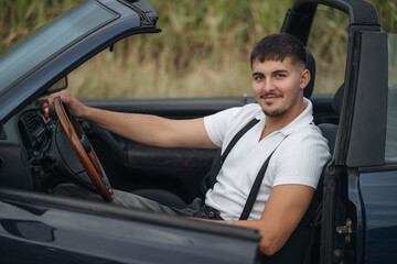 Young man driving car, holding steering wheel with focus on road ahead. Concept of travel, road trip, lifestyle, freedom, and modern journey.