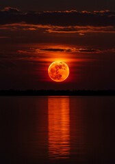 Fiery Full Moon Rising Over Still Waters Reflected in a Dark Landscape