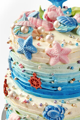 Delicious ocean-themed cake decorated with mermaid tail, seashells, and starfish