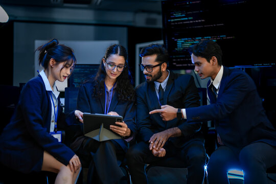 A development team participates in a project debriefing in a corporate command center. They are analyzing post-launch metrics and discussing the next development sprint and strategy.