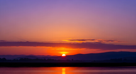 Fototapeta premium Vibrant Sunrise over Calm Waters A Serene Landscape Photography