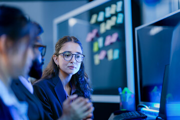 An agile development team participates in a sprint retrospective meeting. A female developer...