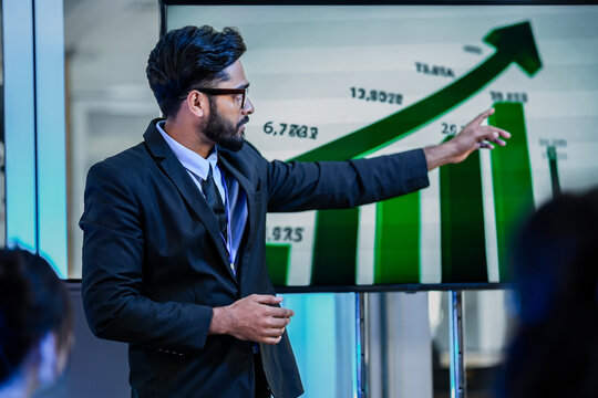A senior software architect leads a code review session, explaining a complex algorithm to junior developers. He uses a stylus to highlight specific functions on the main display.