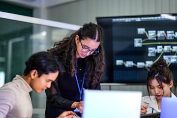 A data science team collaborates on a machine learning workflow. The lead analyst points out a data pipeline issue on a laptop, mentoring junior data scientists on the project.