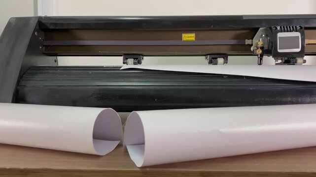 Paper plotter. Flatbed cutting plotter. White vinyl film. Designer's workplace. Time-lapse photography. High-quality 4K filming.